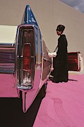 A Model Wearing Emeric Partos Entering A 1965 Photograph by Gene Laurents