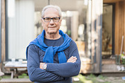 Confident senior man with arms crossed in backyard Photograph by Portra
