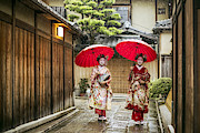 Geishas holding red umbrellas during rainy season Photograph by Xavier Arnau