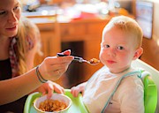 Mother Feeding Her Toddler In A High Chai Photograph by Science Photo Library
