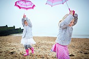 Two Girls On Beach Holding Umbrellas Photograph by Science Photo Library