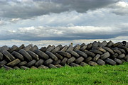 Stack of used tires in green field Photograph by Sami Sarkis Photography