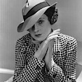 A Young Model Wearing A Tilted Hat With Her Hands