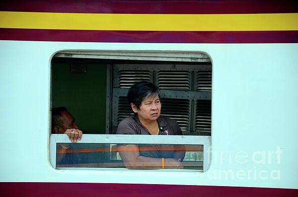 Thai woman rail passenger looks out of train carriage window