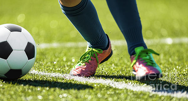 Soccer player in position to kick a football. Footballer practicing his  game on field early in the morning. stock photo