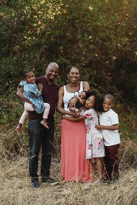 Portrait Of Young Family And Three Girls Standing In Field Greeting Card by  Cavan Images