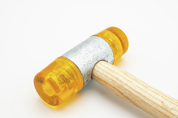 A small orange rubber mallet lying on a white background #2 Jigsaw Puzzle  by Stefan Rotter - Pixels