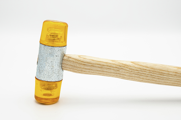 A small orange rubber mallet lying on a white background #2 Jigsaw Puzzle  by Stefan Rotter - Pixels