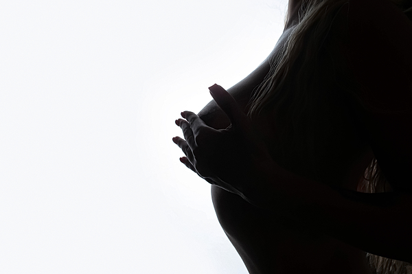 Woman With A Big Breast In A White T-shirt On Dark Background