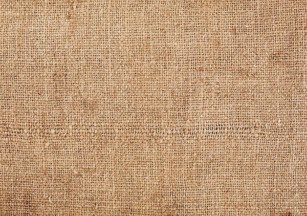 Brown burlap laying on white sheet. Abstract background. Texture