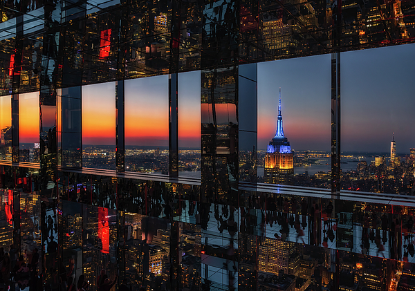 Man looking through window at cityscape stock photo - OFFSET