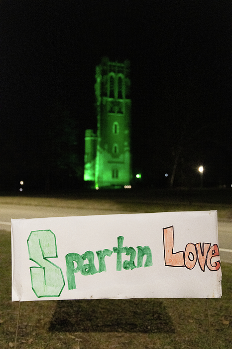 Spartan Love sign in front of green lit Beaumont Tower at night at Michigan State University Greeting Card