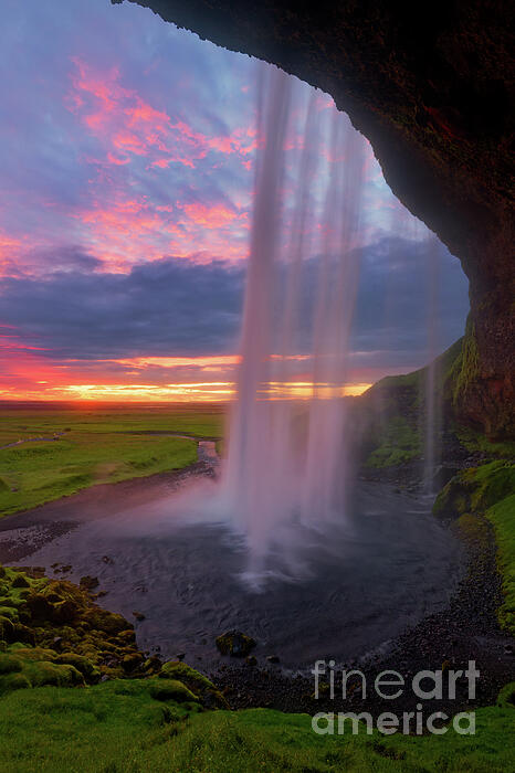 Vivid Sunset Behind Seljalandsfoss Waterfall in Iceland