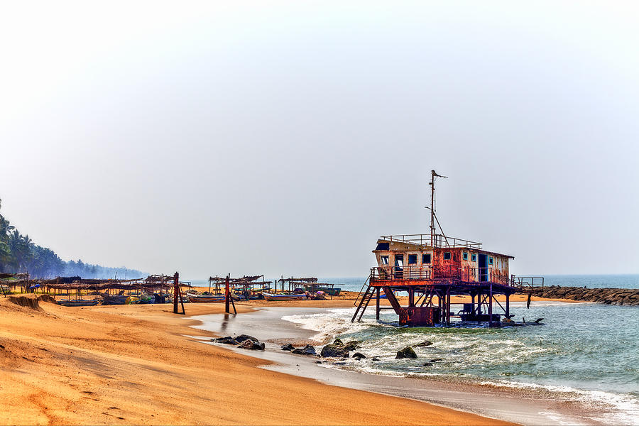 a rusty colorful shipwreck projects out of the water of the Indian Ocean at the coast of Sri Lanka #1 Photograph by Gina Koch