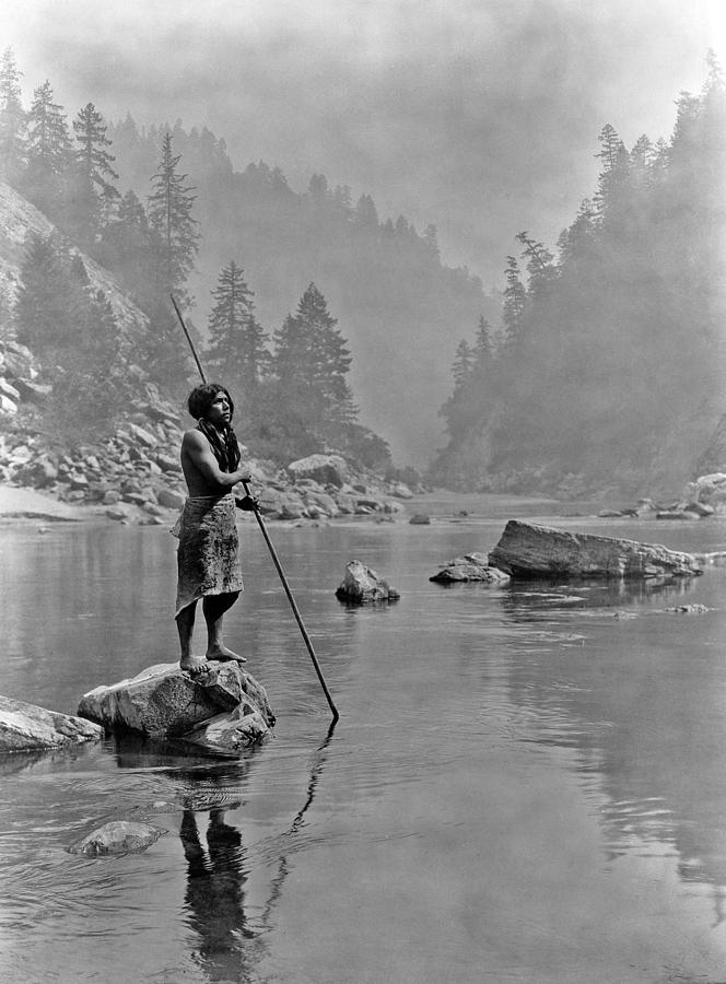 Nature Painting - A smoky day at the Sugar Bowl-Hupa, c. 1923. Hupa man with spear, standing on rock midstream by E Cu #1 by Celestial Images