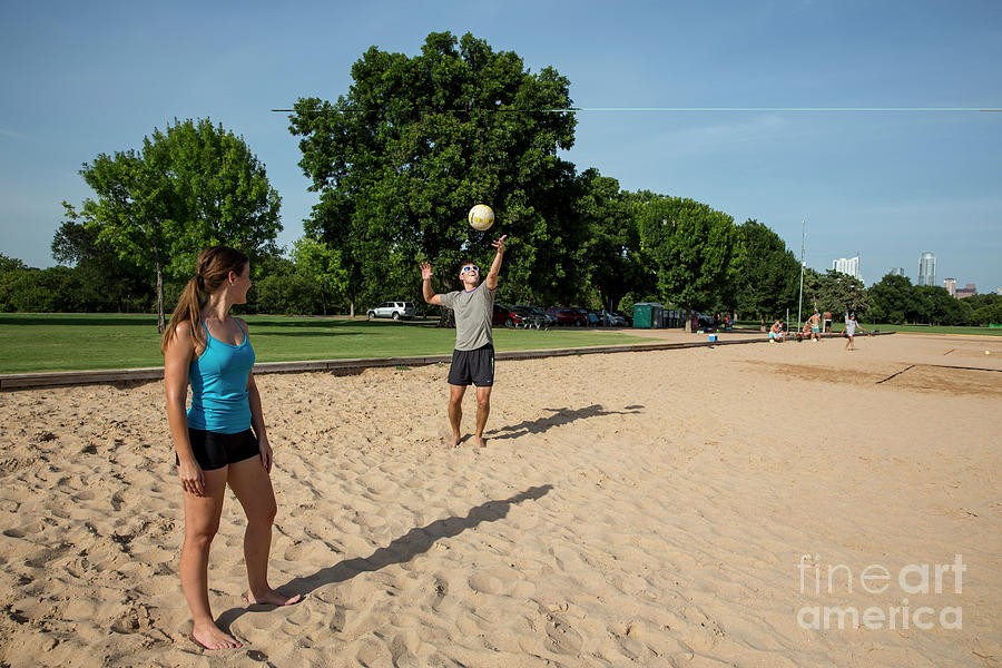 Summer Photograph - A young couple enjoy in summer vacation playing volleyball at Zilker Park sand volleyball courts #1 by Dan Herron
