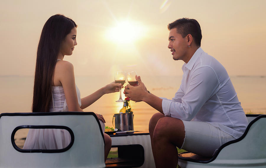 Asian couple in romantic dinner with sea beach and sunset in Thi #1 Photograph by Anek Suwannaphoom