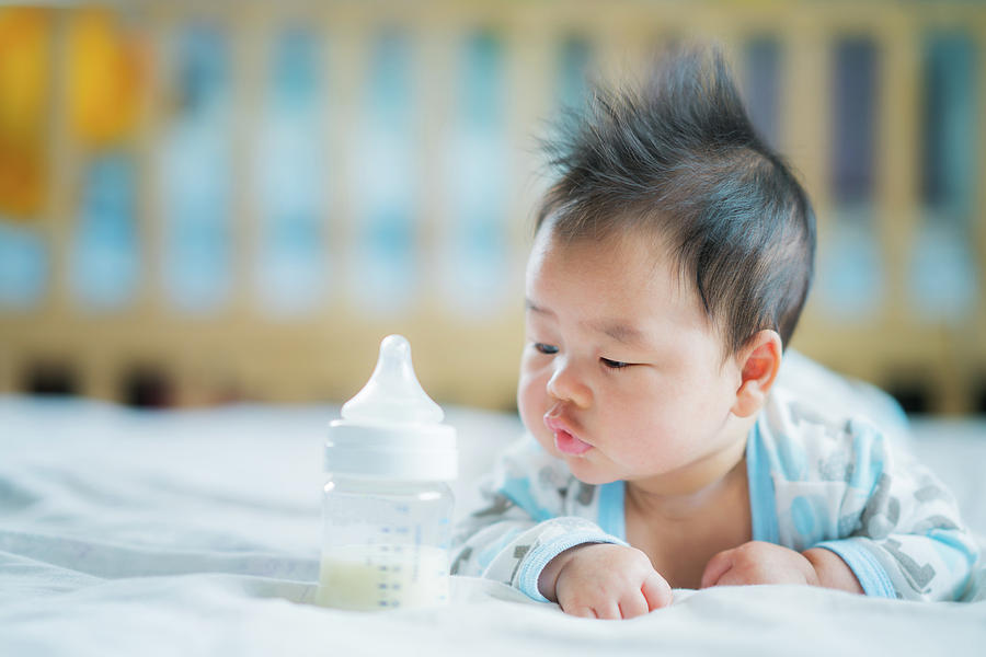 Asian Newborn baby smile with milk power bottle #1 Photograph by Anek Suwannaphoom