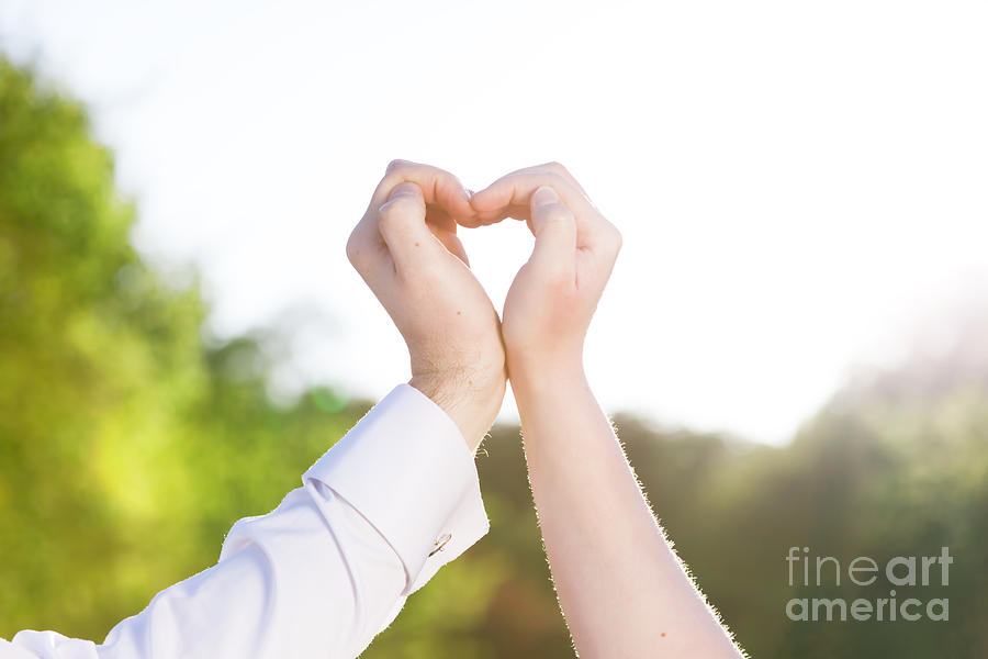 Couple in love making a heart shape with their hands outdoors #1 Photograph by Michal Bednarek