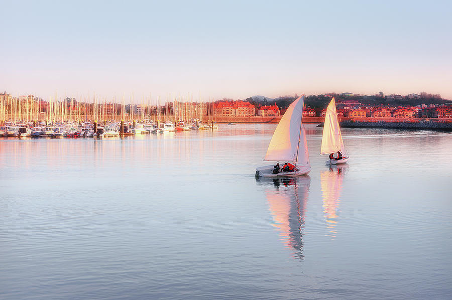 couple of sailboats in Getxo port at sunset #1 Photograph by Mikel Martinez de Osaba