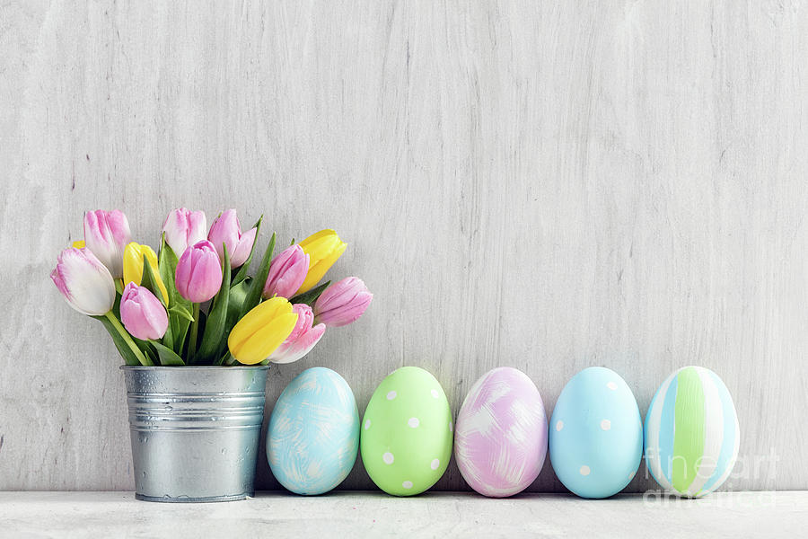 Easter eggs and a spring bouquet of tulips on a wooden table. #1 Photograph by Michal Bednarek