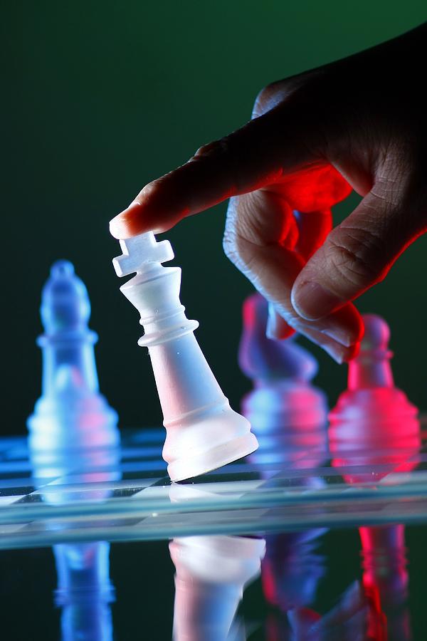 Chess Photograph - Finger tilting a chess piece on Chess Board #1 by Jun Pinzon