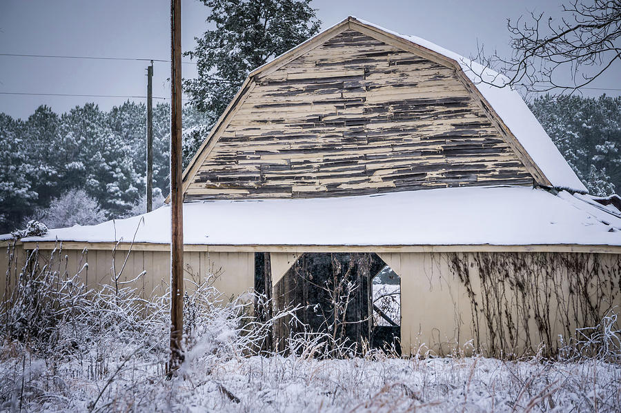 Fresh snow sits on the ground around an old barn #1 Photograph by Alex Grichenko