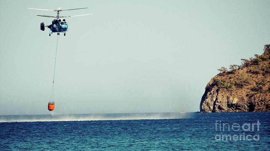 Helicopter firefighter take water in the sea #1 Photograph by Raimond Klavins