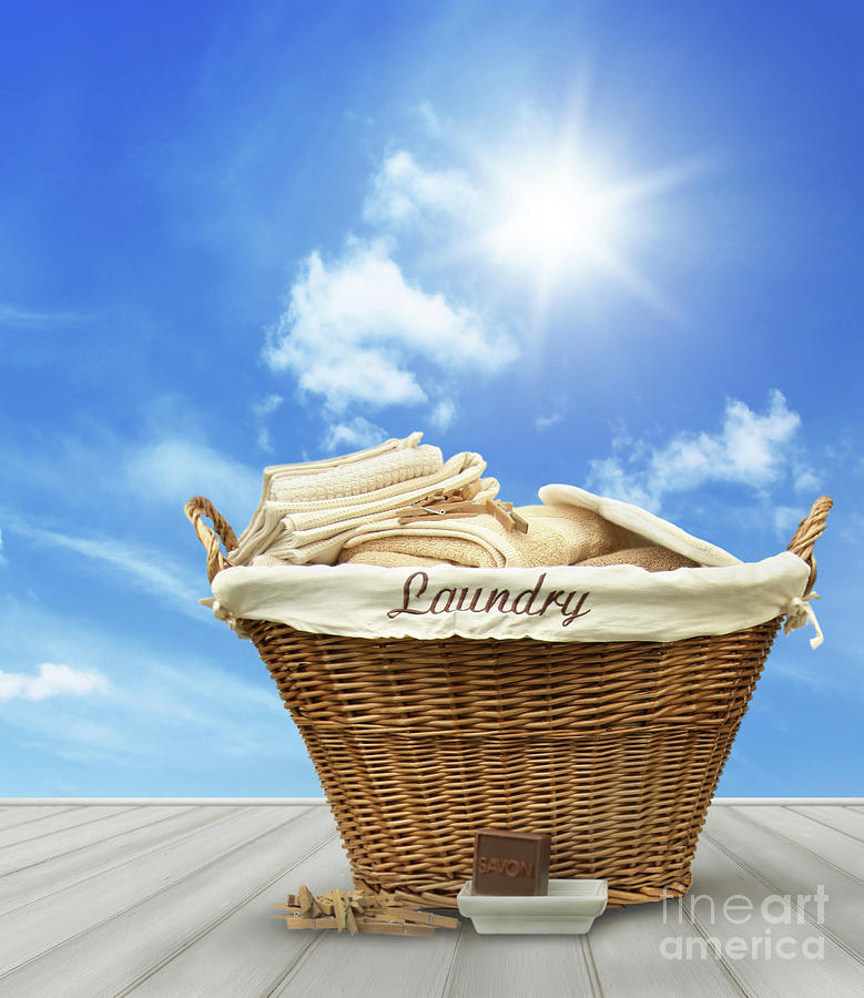 Laundry basket with clothes on rustic table against blue sky #1 Photograph by Sandra Cunningham