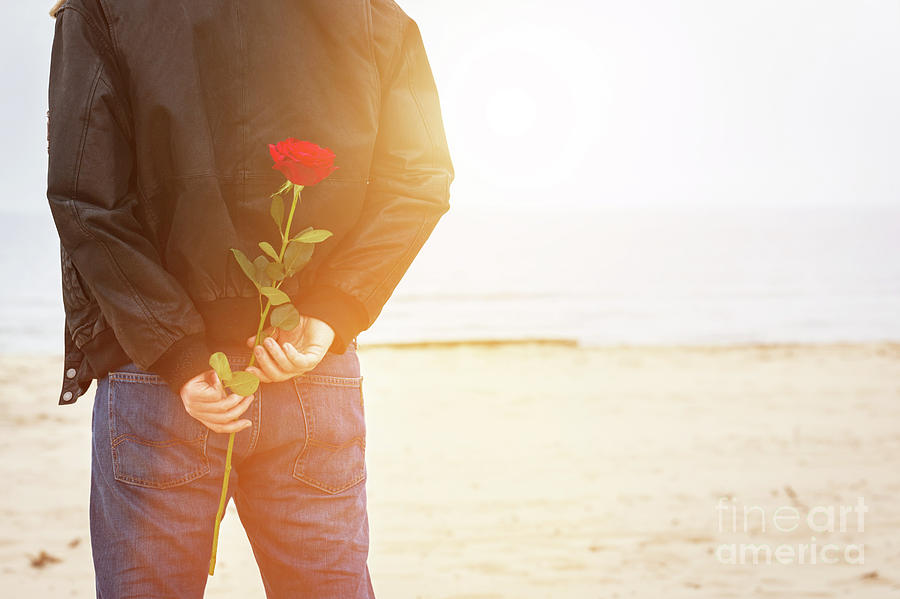 Man with a rose behind his back waiting for love. Romantic date on the beach #1 Photograph by Michal Bednarek