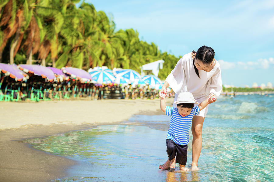 Mother and baby walking on the beach #1 Photograph by Anek Suwannaphoom