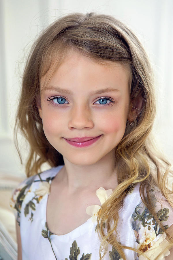 Portrait Of A Girl Seven Years Old With Blond Hair And White Dress