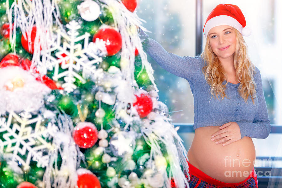 Pregnant woman adorns Christmas tree #1 Photograph by Anna Om