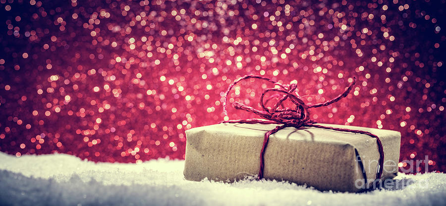 Retro rustic Christmas gift, present in snow on glitter background #1 Photograph by Michal Bednarek