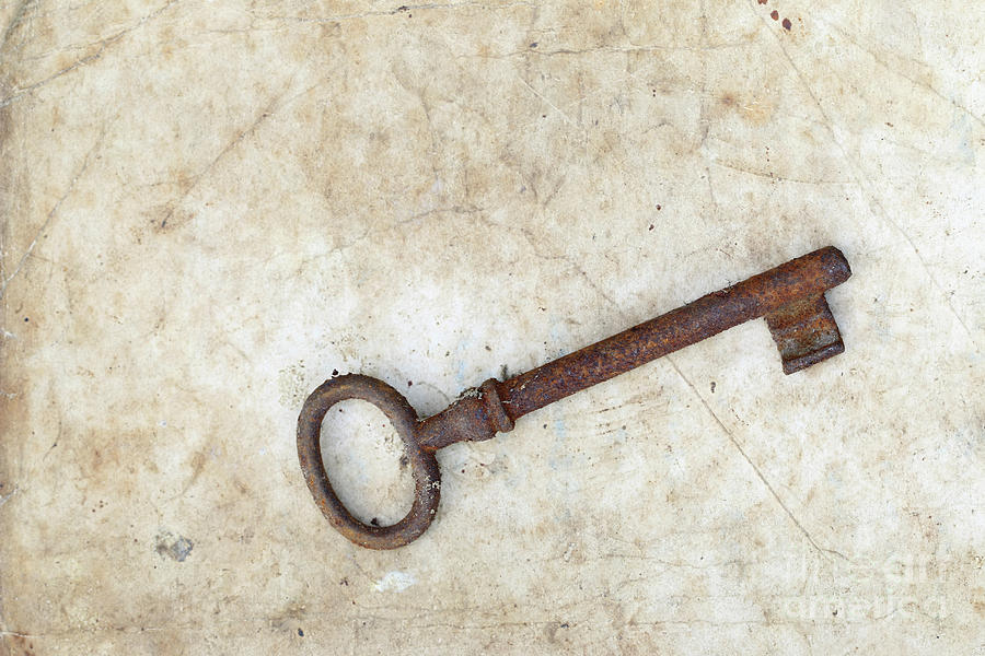 Rusty key on old parchment #1 Photograph by Michal Boubin