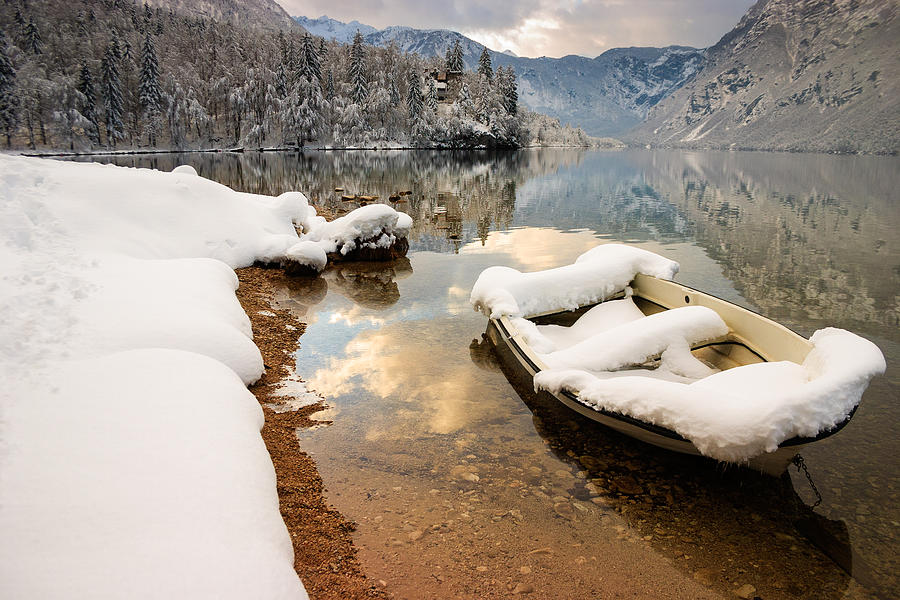 Snow covered boat on Lake Bohinj in Winter #1 Photograph by Ian Middleton