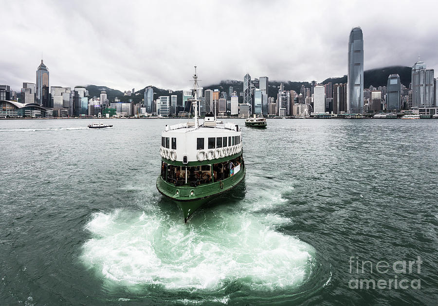 Star ferry on a cloudy sky with the famous skyline in Hong Kong. #1 Photograph by Didier Marti