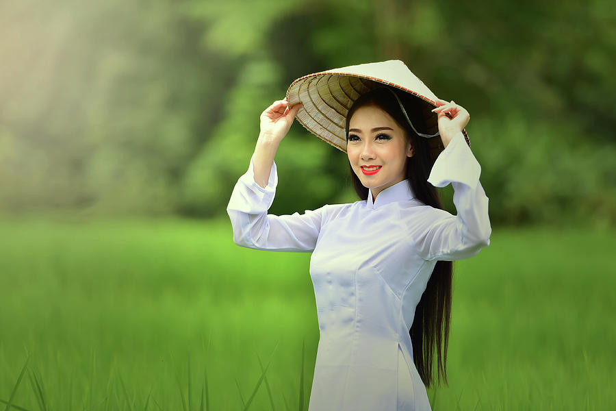 The girl dressed in traditional Vietnamese dress. #1 Photograph by