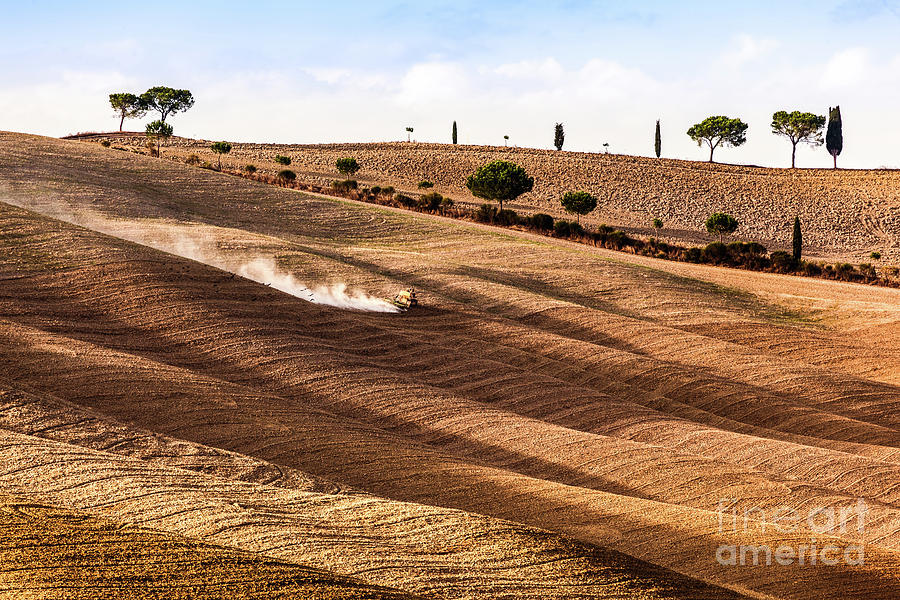 Fall Photograph - Tuscany fields autumn landscape, Italy. Harvest season, tractor working #1 by Michal Bednarek