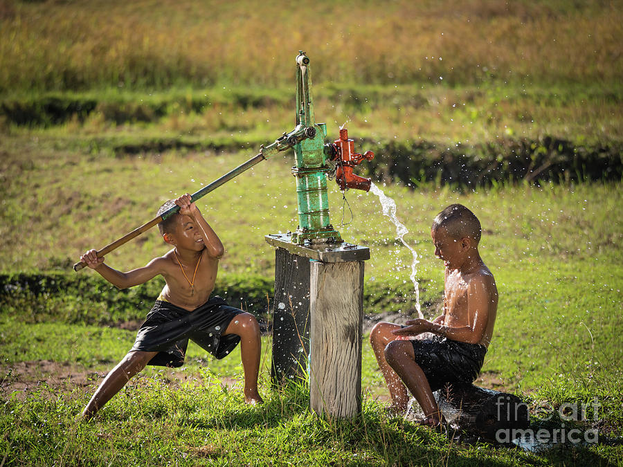 Two young boy rocking groundwater bathe in the hot days. #1 Photograph by Tosporn Preede