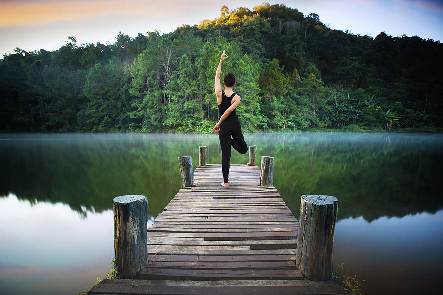 Yoga post on the wooded bridge  #1 Photograph by Anek Suwannaphoom