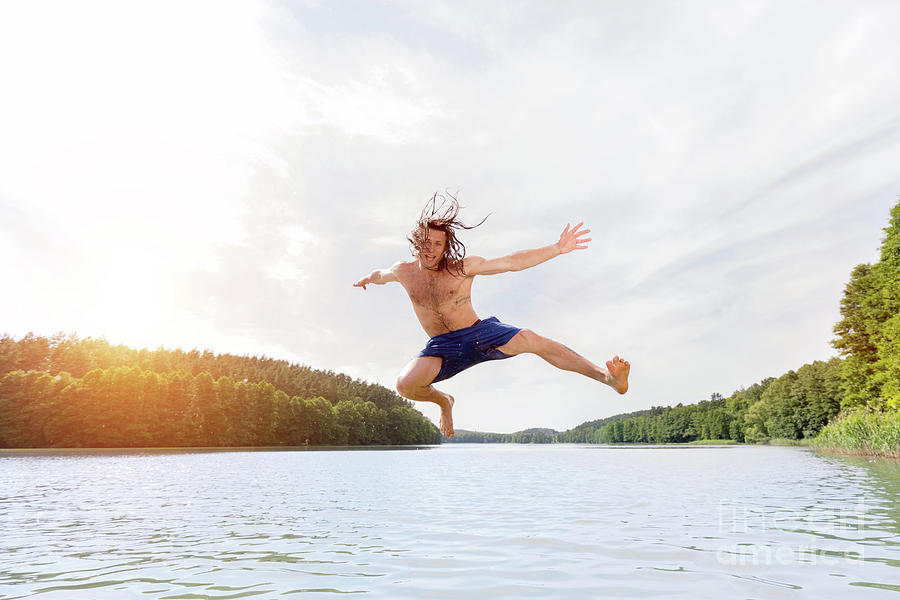 Young Fit Man Making A Jump Into A Lake. Photograph By Michal Bednarek 