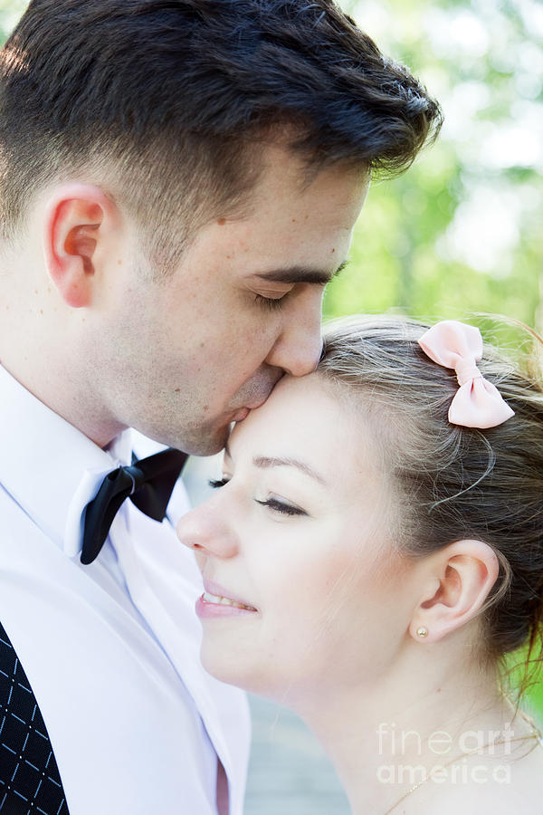 Young handsome man gently kissing his fiancee #1 Photograph by Michal Bednarek