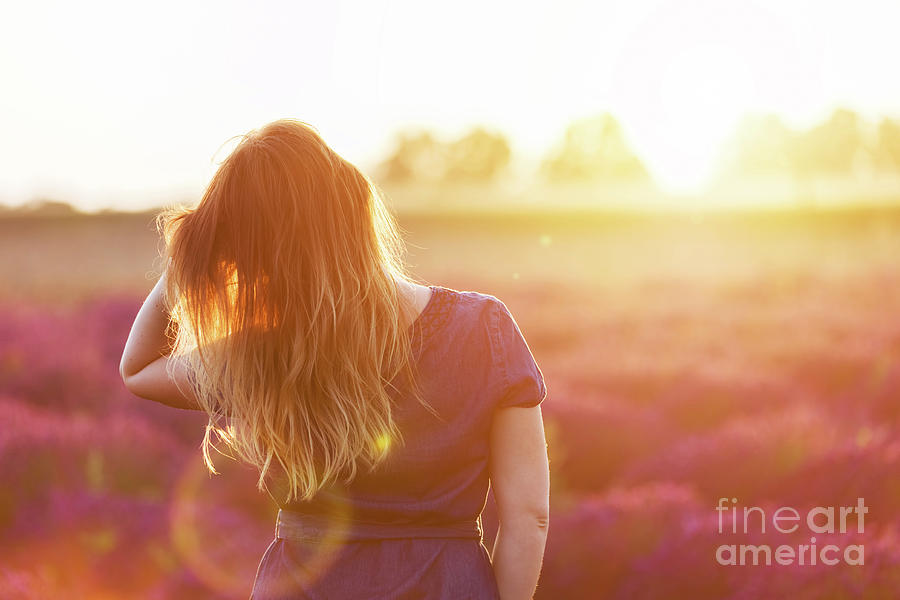 Sunset Photograph - Young woman touching her long sombre hair looking at lavender field at sunset #1 by Michal Bednarek