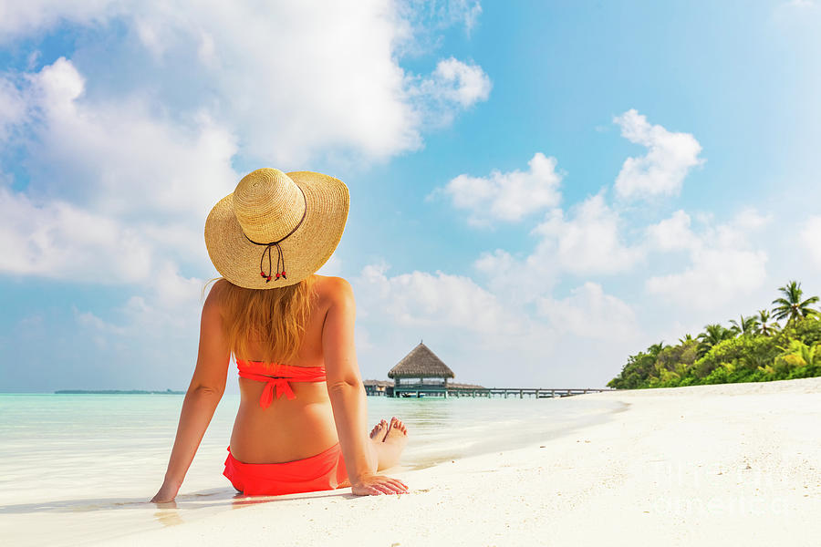 Beautiful young woman in sunhat sitting relaxed on tropical beach in Maldives #2 Photograph by Michal Bednarek
