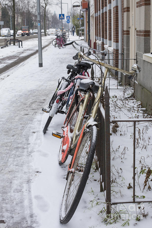 Bikes on a street in the snow Photograph by Patricia Hofmeester