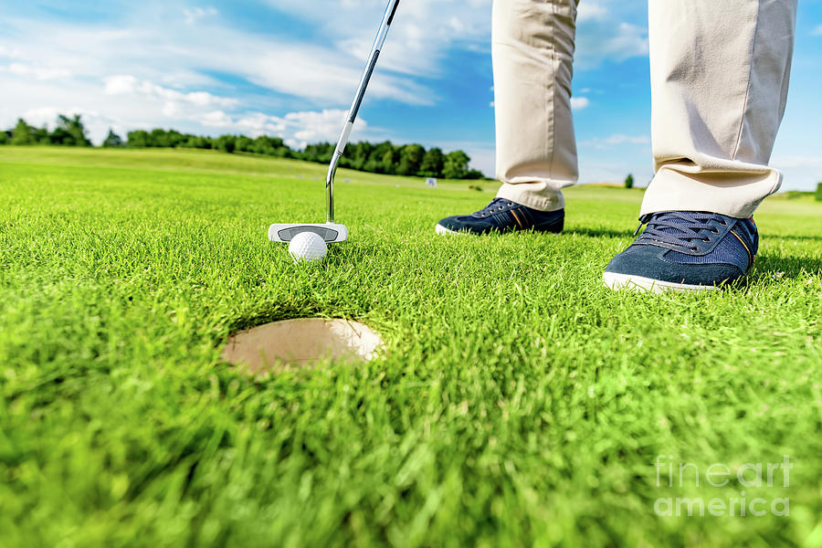 Golfer putting ball in the hole on a golf course. #2 Photograph by Michal Bednarek