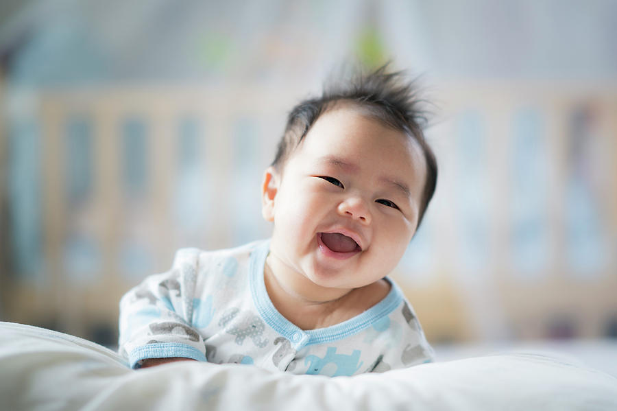 Newborn boy smile on the bed #2 Photograph by Anek Suwannaphoom