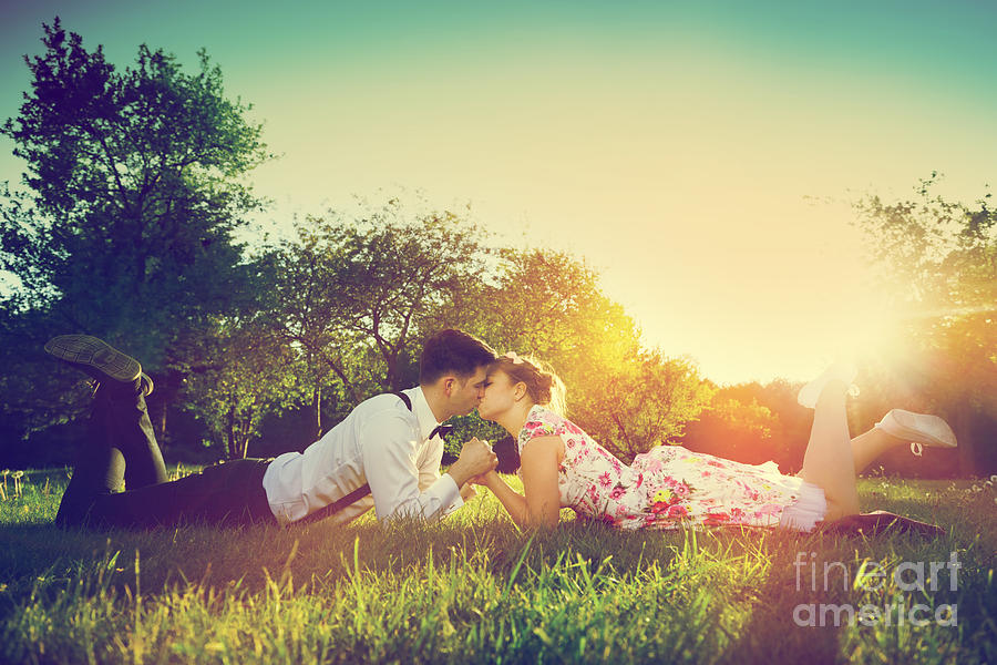 Romantic couple in love kissing while lying on grass #2 Photograph by Michal Bednarek