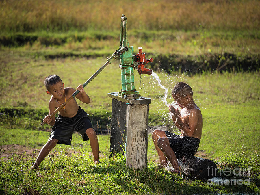 Two young boy rocking groundwater bathe in the hot days. #2 Photograph by Tosporn Preede